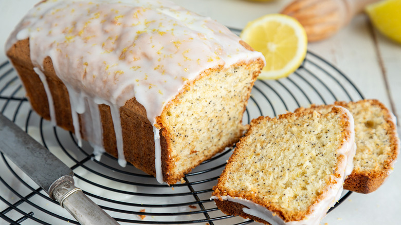 A loaf of glazed lemon pound cake on a round wire rack