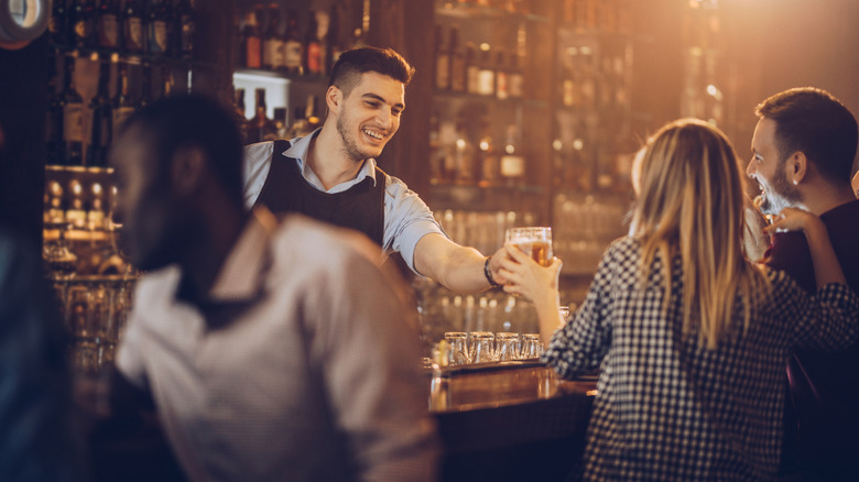 bartender handing cocktail to customer
