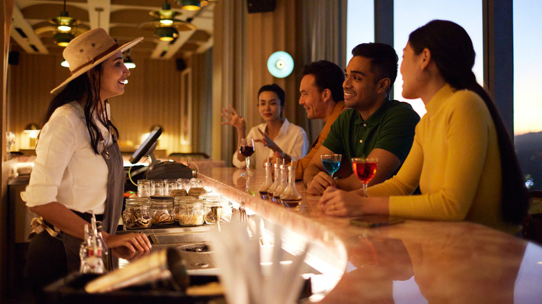 customers sitting at bar with bartender