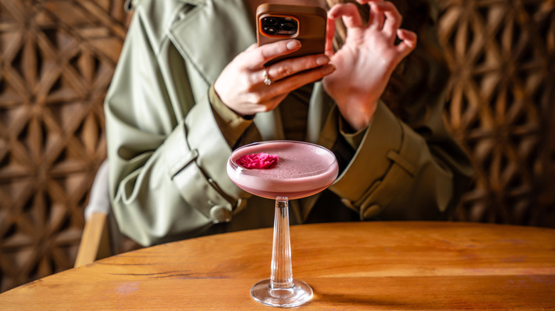 person photographing cocktail