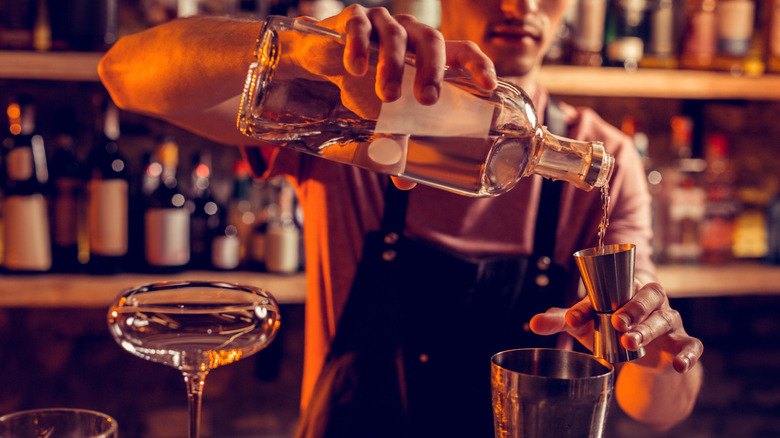 bartender pouring spirit for cocktail