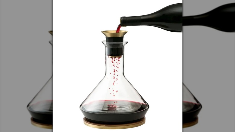 Rabbit brand glass wine decanter full of red wine with bottle pouring wine into funnel