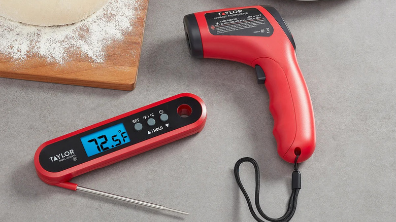 Two Taylor brand digital food thermometers on gray table