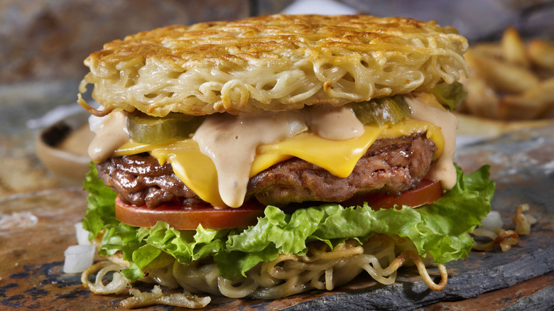 Ramen burger with cheese, burger sauce, pickles, lettuce, and tomatoes