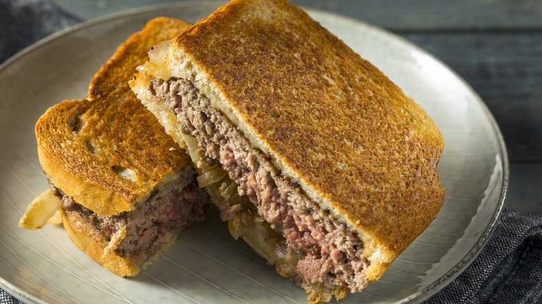 Halved patty melt sandwich on plate