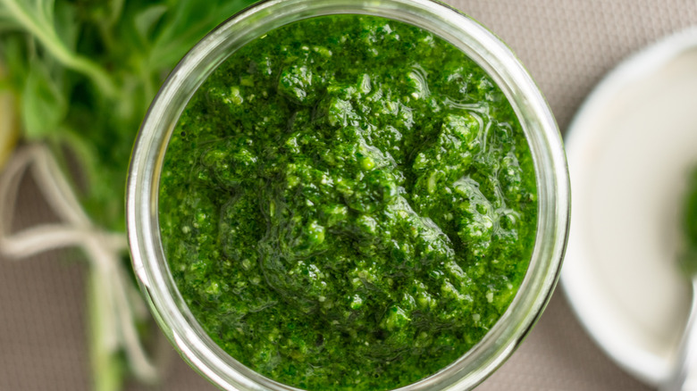 Topview of an open jar of green pesto