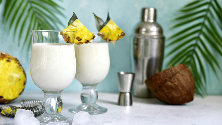 Two pina coladas and a bar set up including a shaker