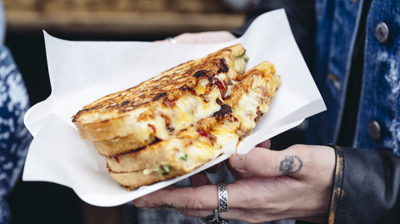 Woman holding grilled cheeese sandwich