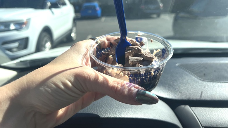 Hand holding Culver's Flavor of the Day cup with spoon.