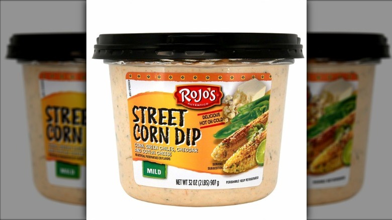 Rojo's street corn dip in a plastic container with black lid on a white background.