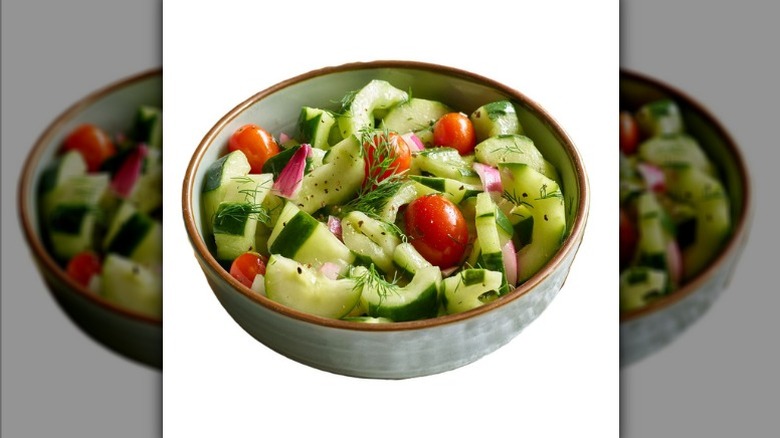 A bowl of The Fresh Market's deli dilly cucumber salad with fresh dill, onions, and tomatoes.