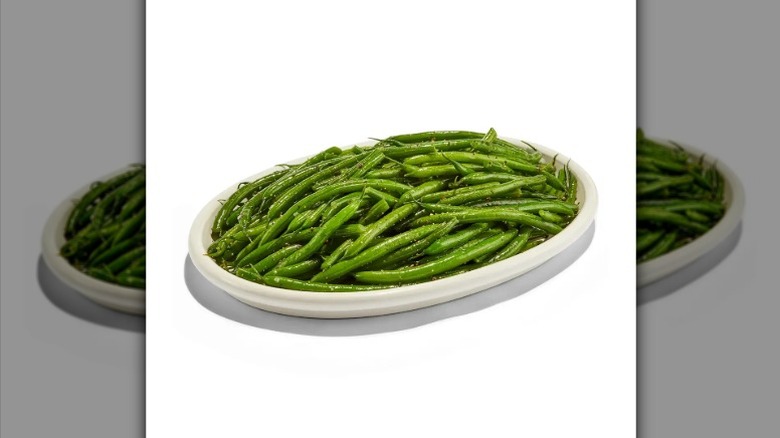 Whole Foods Market sea salt and cracked pepper green beans in a white dish on a white background.