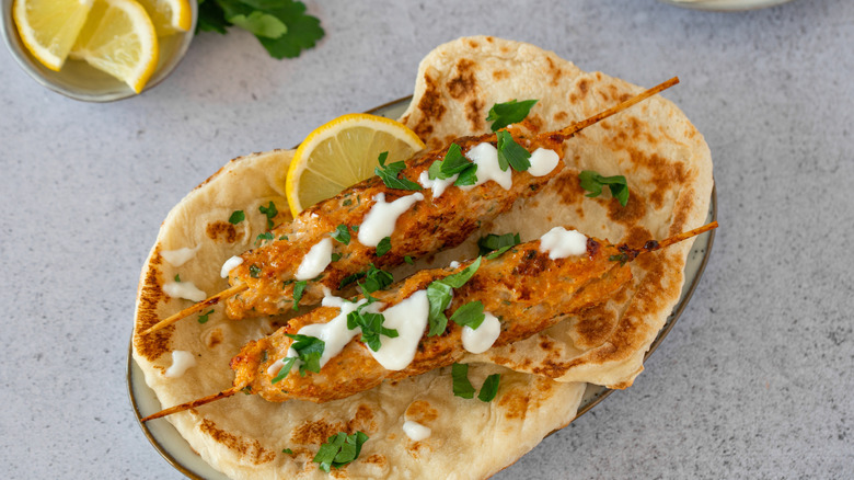 Toum garlic spread on skewered kebabs