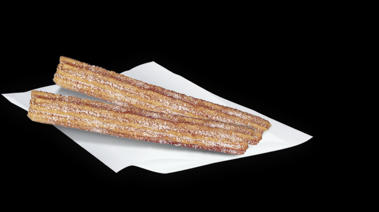 Cinnamon churros from Del Taco against a black wall