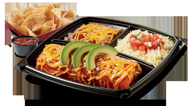 Del Taco plato with an enchilada and rice on a platter with chips and salsa on the side
