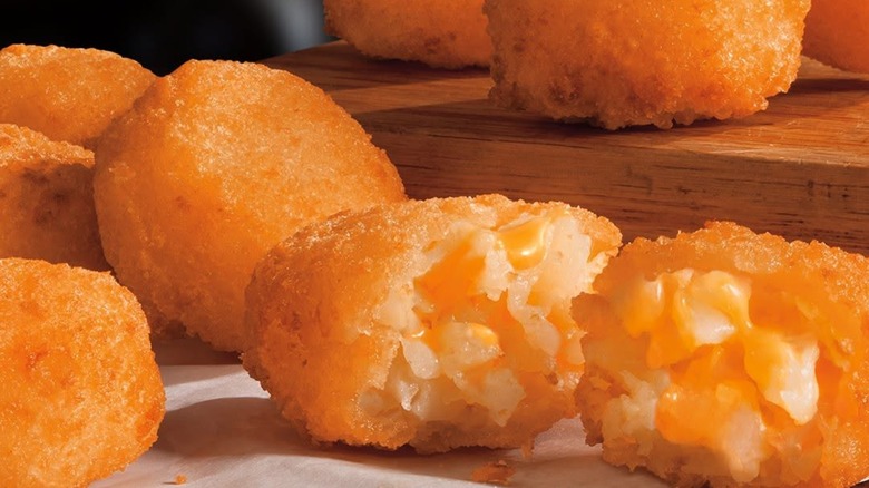Pile of cheesy tots on wooden board