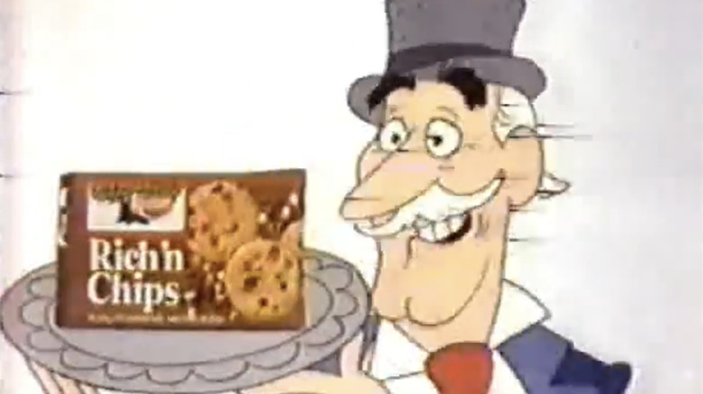 Still from Keebler Ad with a rich man in top hat holding the Rich'n Chips box