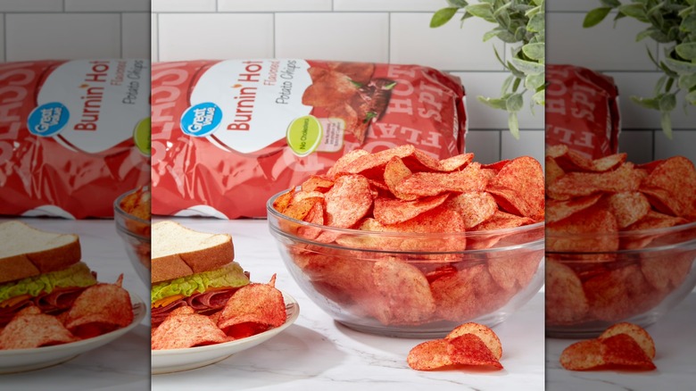 Bowl of Great Value Burnin Hot potato chips next to sandwich on plate, bag in background