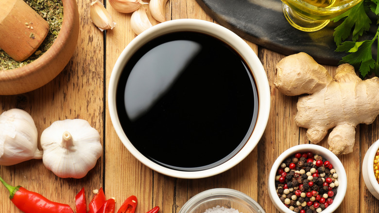 Soy sauce surrounded by aromatics for a marinade