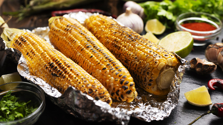 Corn wrapped in tin foil with char marks