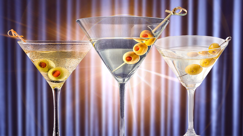 three martini glasses with olives