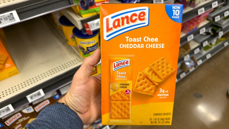 hand holding Lance Toast Chee Cheddar Cheese Crackers in Grocery Store