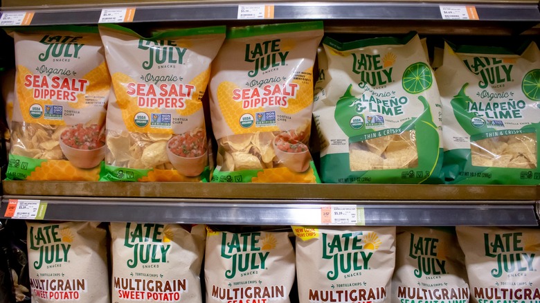 A view of several packages of Late July chips on grocery store shelves