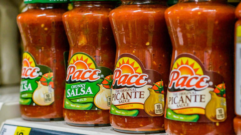 Pace picanta sauce in a row on a grocery store shelf