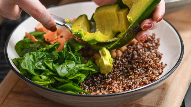 Woman working on a loaded salad