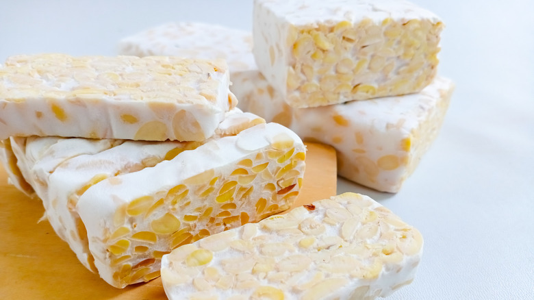 Raw tempeh sliced and whole on a plate