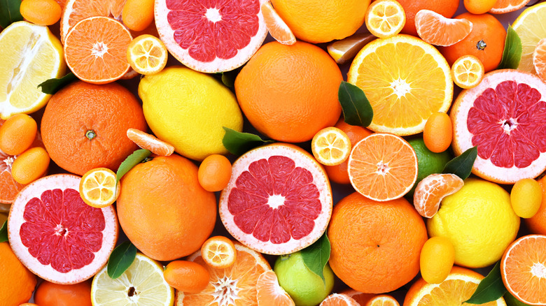 Variety of whole and cut citrus fruit whole and sliced