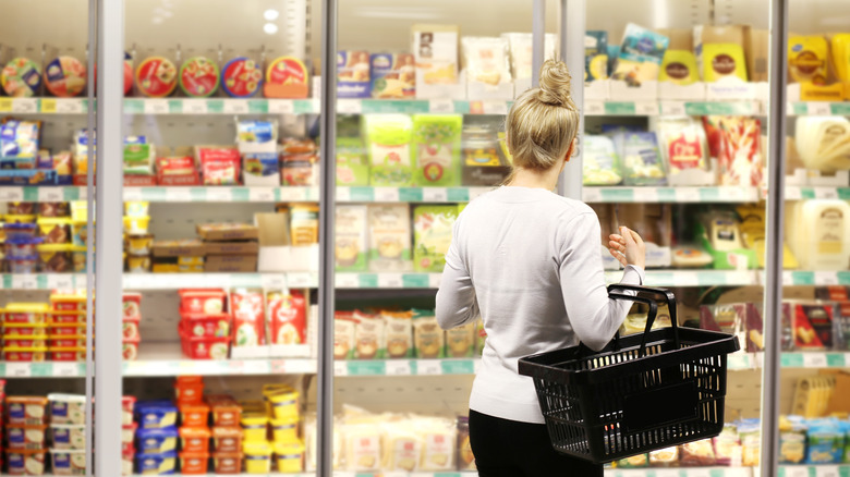 A woman shopping for frozen food.