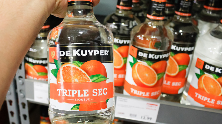 Los Angeles, California, United States - 02-19-2020: A view of a hand holding a bottle of De Kuyper Triple Sec Liqueur, on display at a local grocery store.