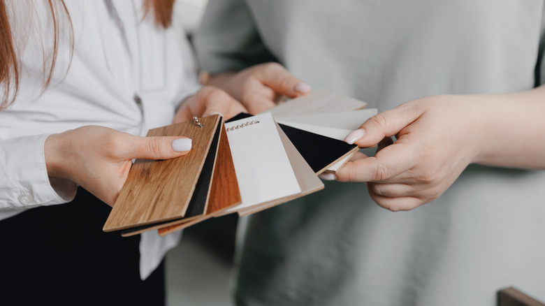 People holding samples of cabinet materials