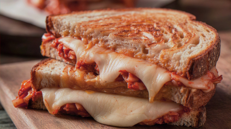 Kimchi grilled cheese sandwich stacked on wooden board