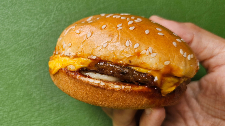 hand holding burger king cheeseburger