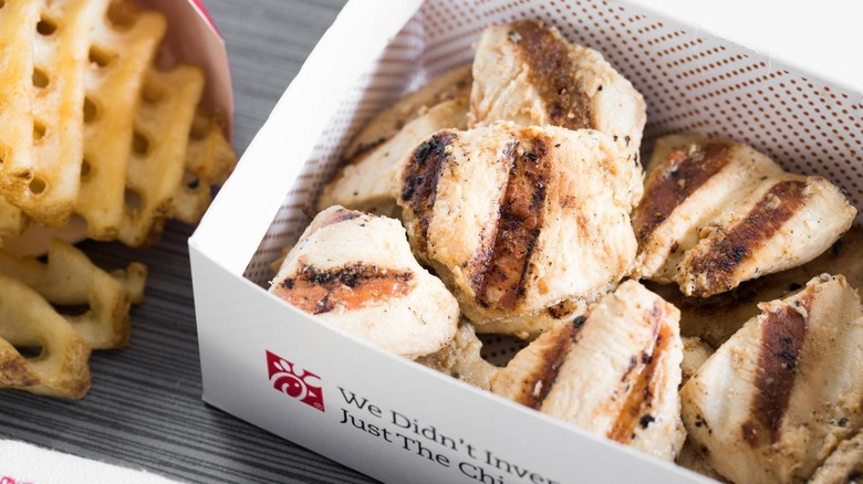 container of Chick-fil-A chicken nuggets with waffles fries on the side