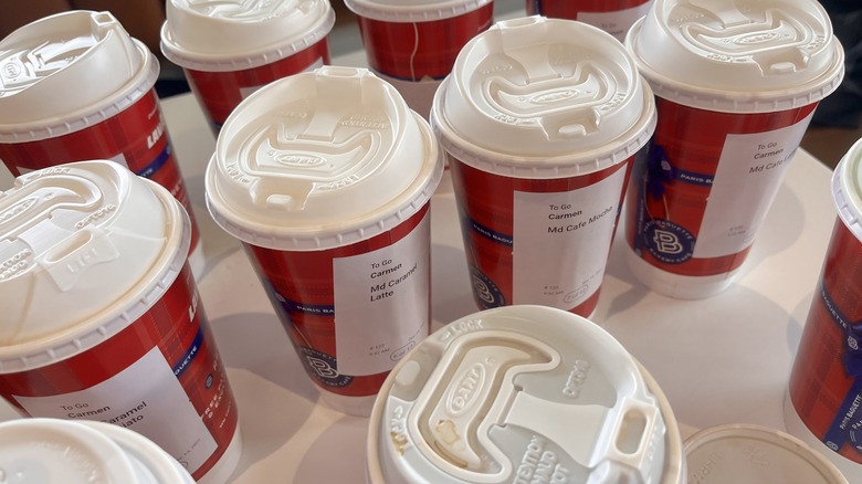 Different drinks in red cups on table