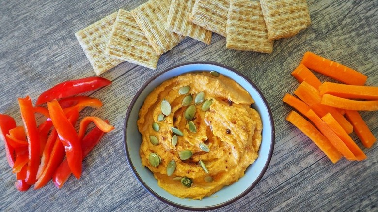 3-Ingredient Pumpkin Hummus in blue bowl with crackers and veg