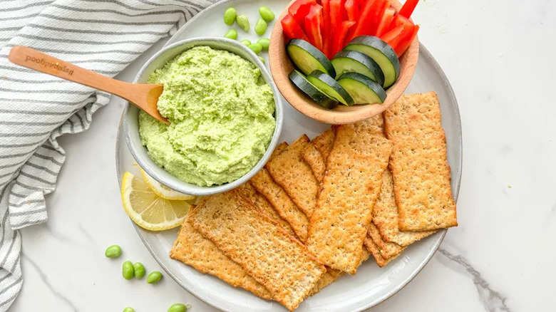 5-Ingredient Edamame Hummus with crackers and cut vegetables