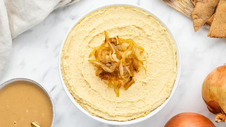Caramelized Onion Hummus in white bowl on countertop