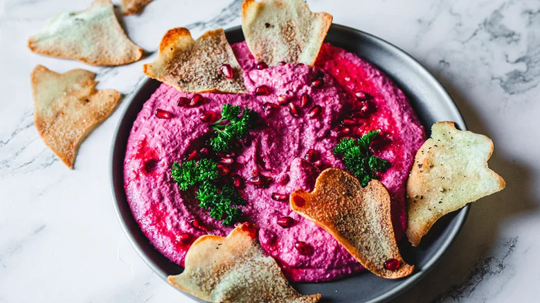 Ghastly Beet Hummus Halloween Appetizer on grey plate with pita chips