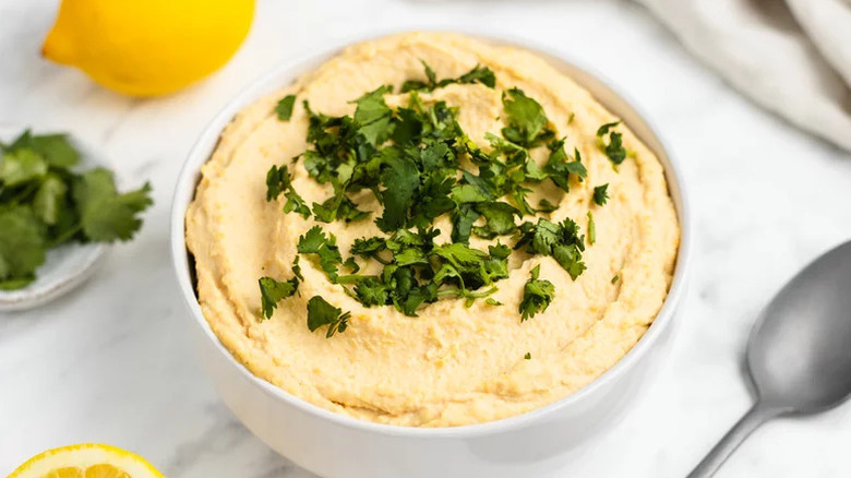 Lemon Hummus in white bowl with parsley on top