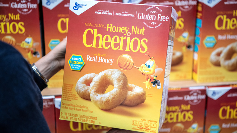 Someone holding a box of Honey Nut Cheerios