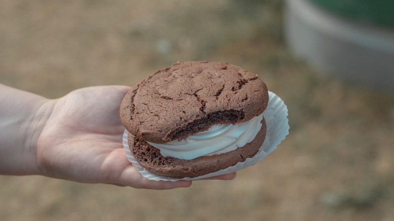 Classic chocolate Whoopie pie held by a hand