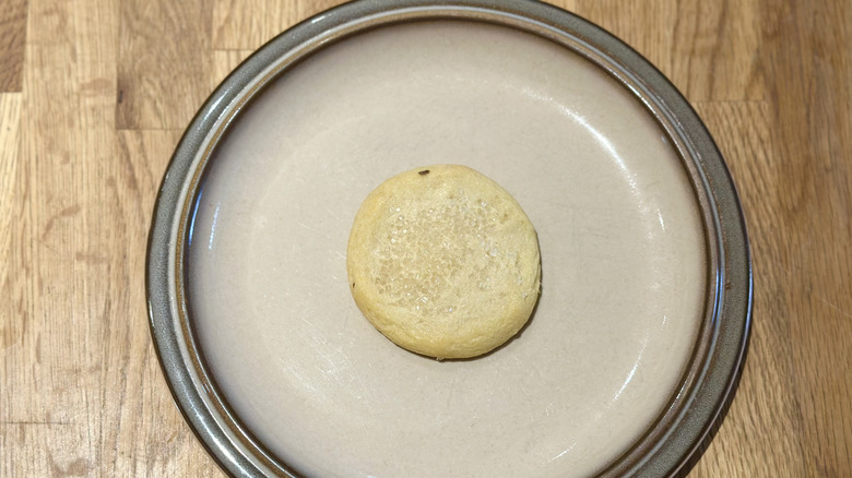 Overhead image of sugar-sprinkled cookie on a plate on a wooden counter