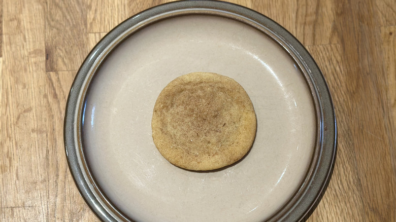 Overhead image of snickerdoodle cookie on a plate on a wooden counter