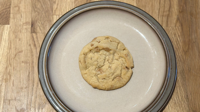 Overhead image of peanut butter cookie on a plate on a wooden counter