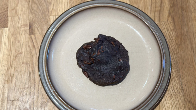 Overhead image of double chocolate cookie on a plate on a wooden counter
