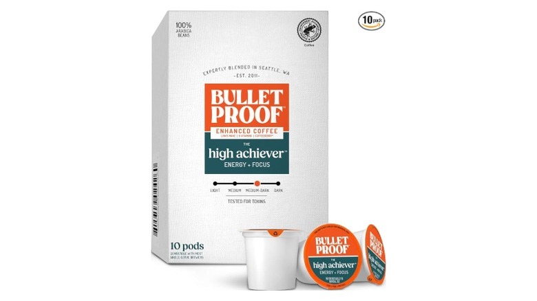 Bulletproof High Achiever Medium-Dark Roast coffee pods in a box, with a couple in front, on a white background